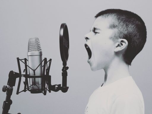 boy singing on microphone with pop filter